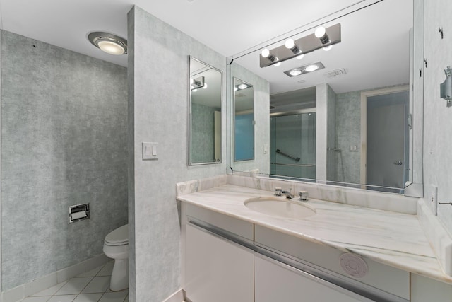 bathroom with an enclosed shower, tile patterned floors, vanity, and toilet