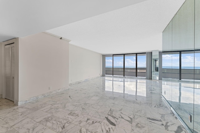 unfurnished living room with a water view, floor to ceiling windows, and a textured ceiling