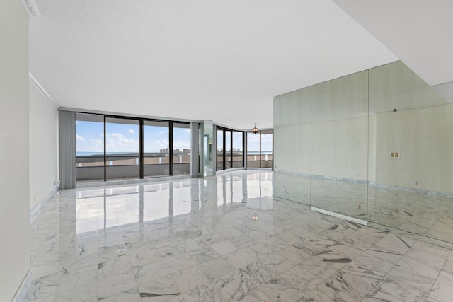 empty room featuring a textured ceiling and a wall of windows