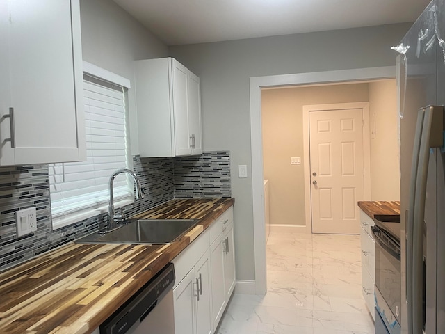 kitchen with backsplash, wooden counters, appliances with stainless steel finishes, and white cabinetry