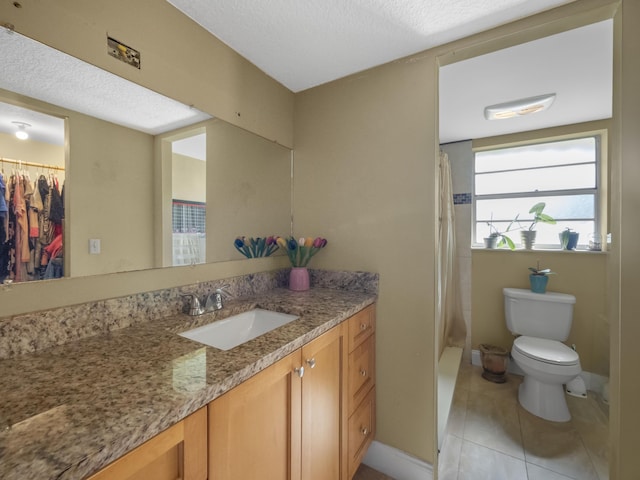 full bathroom with a textured ceiling, shower / bath combo with shower curtain, tile floors, large vanity, and toilet