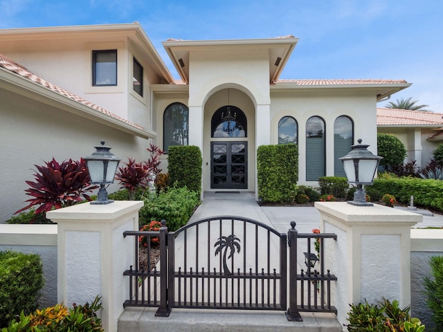 view of front of home with stucco siding and a gate