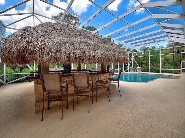 outdoor pool with a lanai, a patio area, and outdoor dry bar