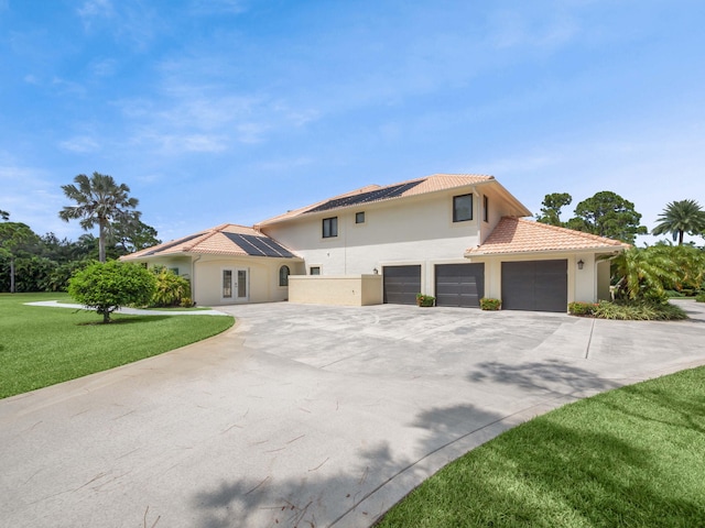 view of front facade featuring stucco siding, concrete driveway, a front lawn, and a tiled roof