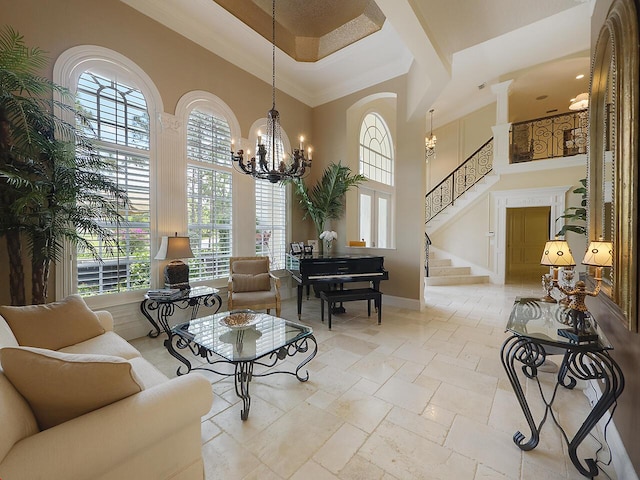 living area featuring stone tile flooring, a high ceiling, an inviting chandelier, baseboards, and stairs