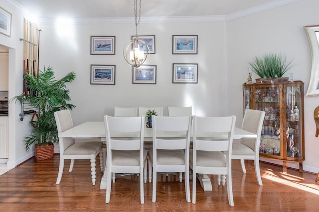 dining room with hardwood / wood-style flooring, crown molding, and a notable chandelier