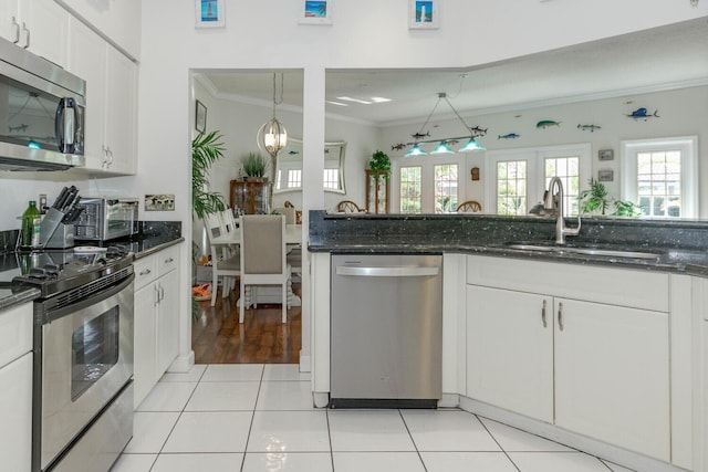 kitchen featuring pendant lighting, appliances with stainless steel finishes, white cabinetry, sink, and light tile patterned flooring