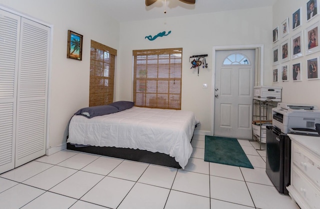 bedroom with ceiling fan, light tile patterned floors, and a closet