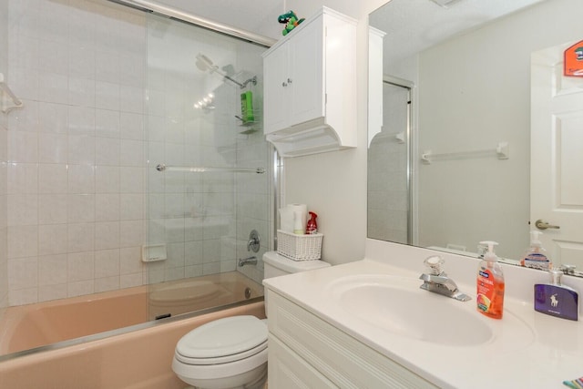 full bathroom with enclosed tub / shower combo, vanity, and toilet