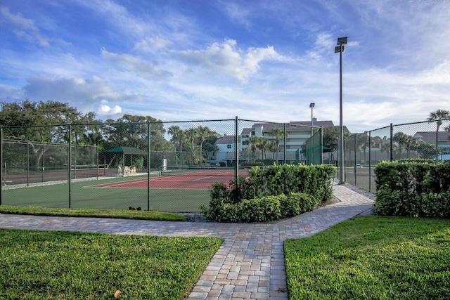 view of tennis court featuring a lawn