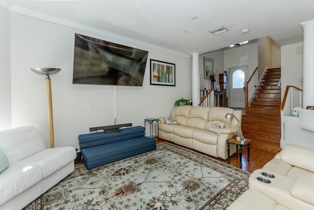 living room featuring ornate columns, ornamental molding, and hardwood / wood-style flooring