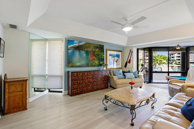 living room featuring a tray ceiling, ceiling fan, light hardwood / wood-style floors, and pool table