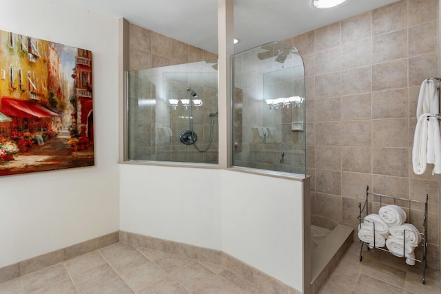 bathroom with tile patterned flooring and a tile shower