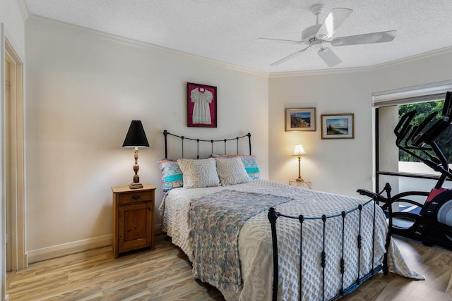 bedroom featuring light wood-type flooring, a textured ceiling, ceiling fan, and crown molding