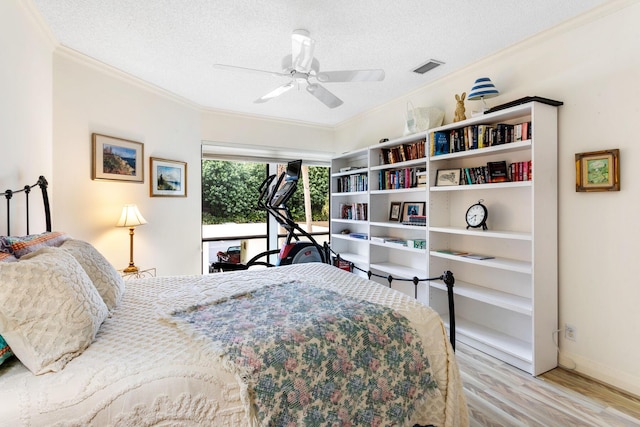 bedroom with a textured ceiling, light hardwood / wood-style flooring, ceiling fan, and crown molding