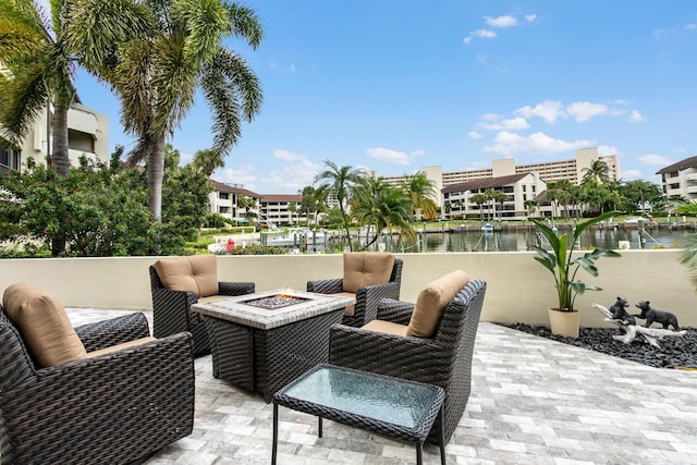 view of patio with a fire pit and a water view