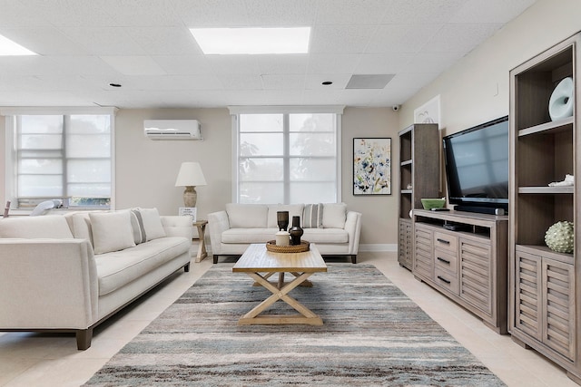 living room with a drop ceiling and a wall mounted AC