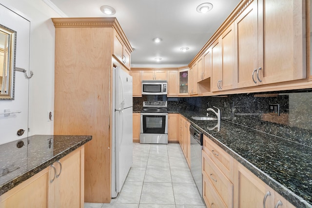 kitchen with decorative backsplash, appliances with stainless steel finishes, dark stone counters, sink, and light tile patterned floors