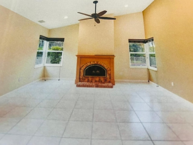 unfurnished living room featuring high vaulted ceiling, ceiling fan, and light tile floors