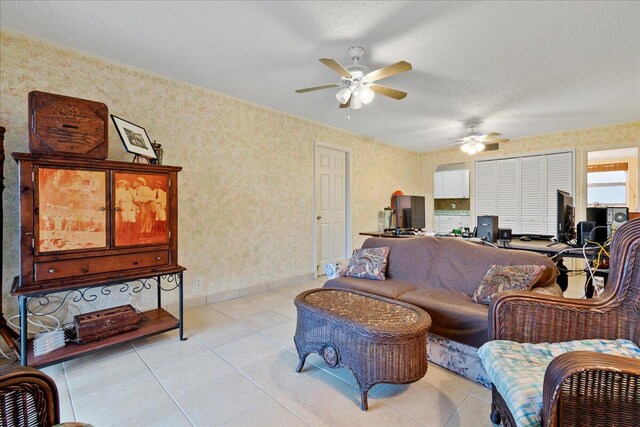 tiled living room with a textured ceiling and ceiling fan