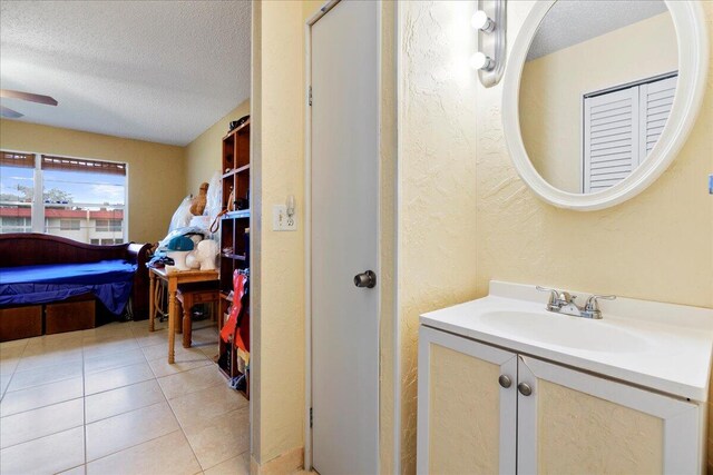 bathroom featuring a textured ceiling, ceiling fan, tile patterned flooring, and vanity