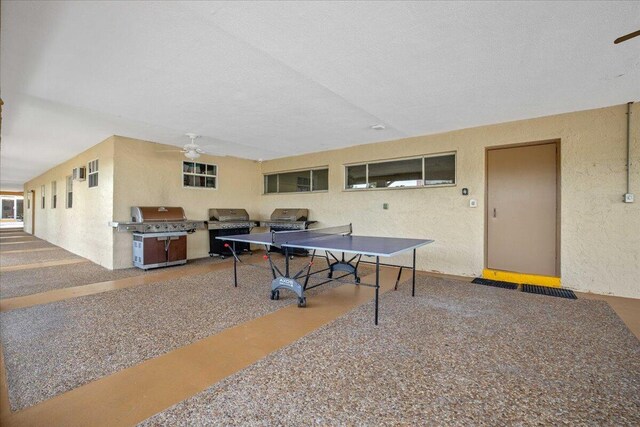 playroom featuring ceiling fan and a textured ceiling