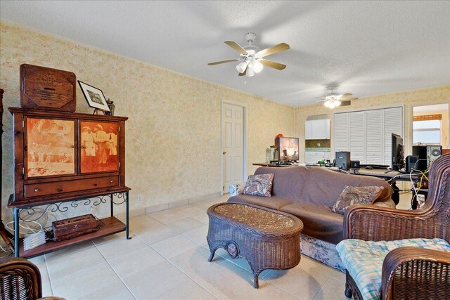 tiled living room featuring ceiling fan and a textured ceiling