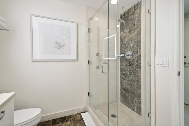 bathroom with an enclosed shower, vanity, tile flooring, and toilet