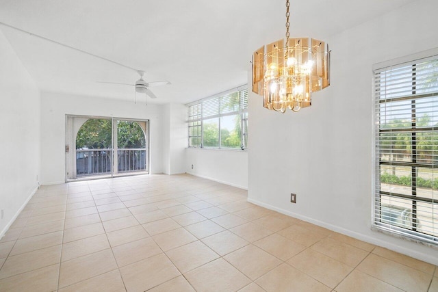 tiled spare room with plenty of natural light and ceiling fan with notable chandelier