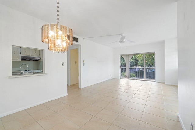 tiled spare room with ceiling fan with notable chandelier