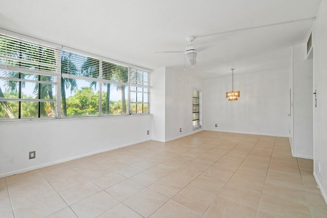 spare room with ceiling fan with notable chandelier and light tile floors