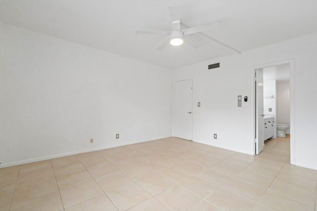 empty room with light tile floors and ceiling fan