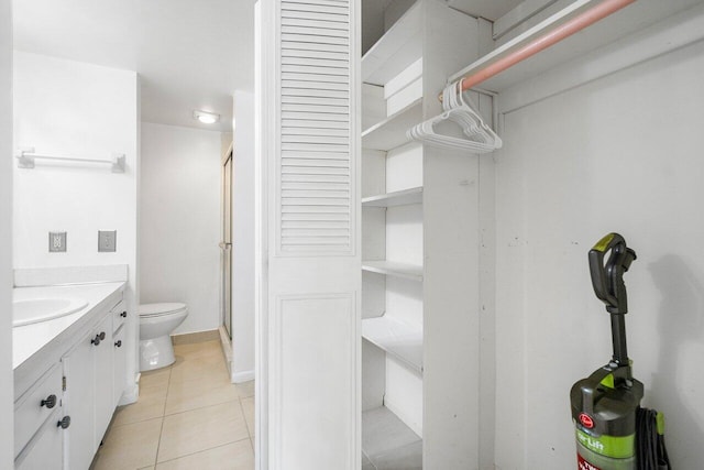 bathroom featuring toilet, tile flooring, and vanity