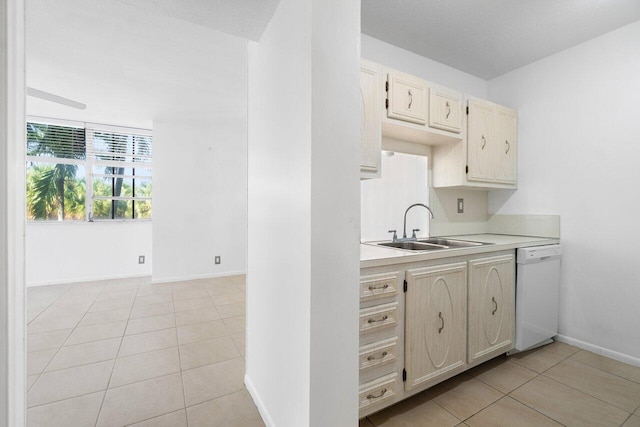 kitchen featuring light tile floors, dishwasher, and sink