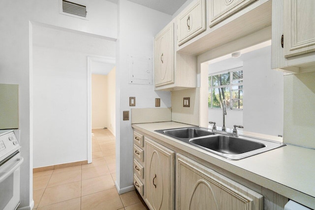 kitchen featuring sink, light brown cabinetry, light tile flooring, and wall oven