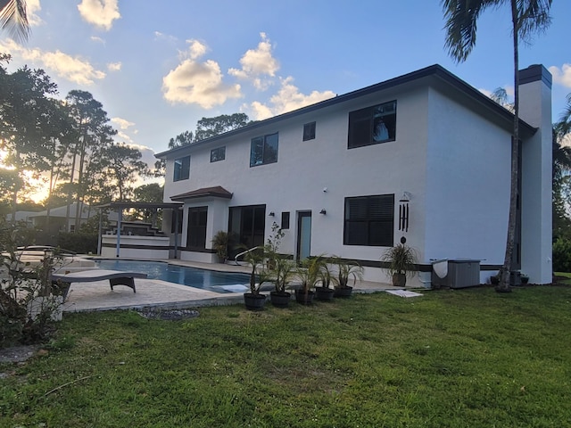 back of house with a patio, central air condition unit, and a yard