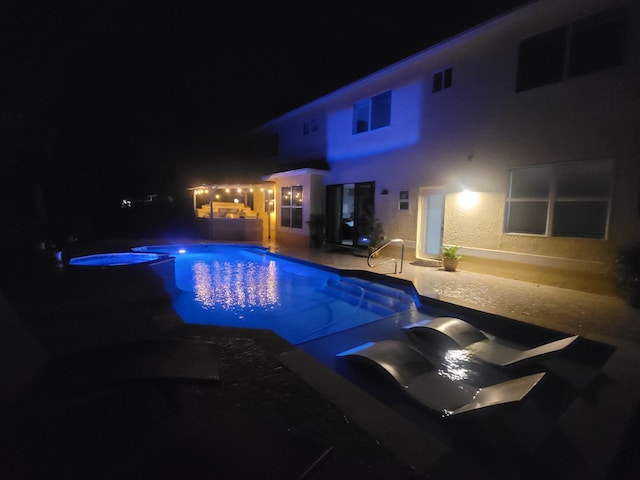 pool at twilight featuring a patio area