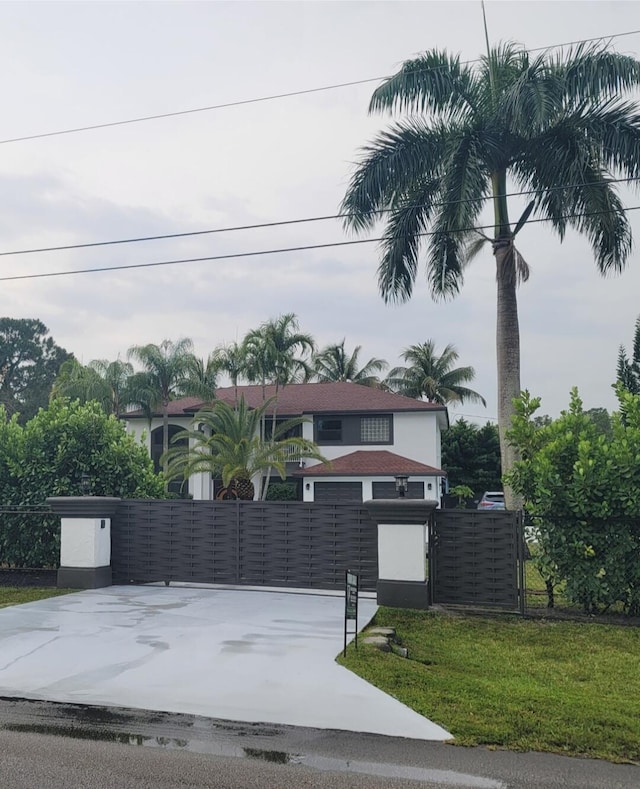 view of front facade with a balcony, a garage, and a front yard