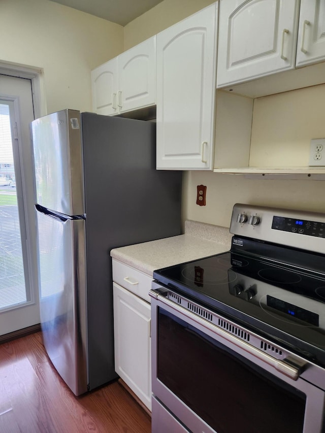 kitchen featuring stainless steel electric range, white cabinetry, and dark wood-type flooring