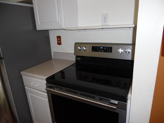 kitchen with white cabinets and stainless steel range with electric stovetop