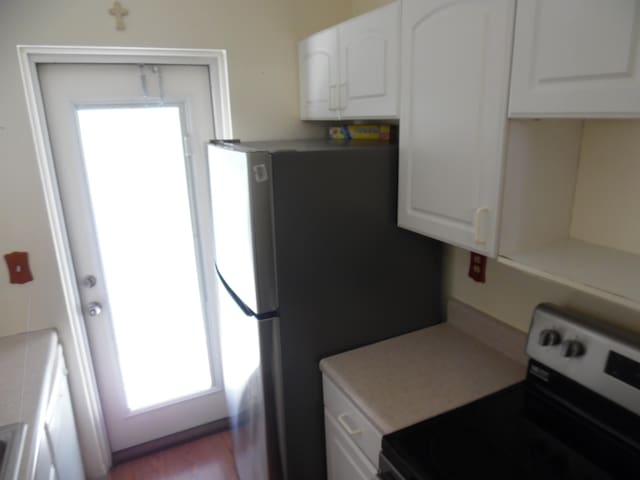 kitchen with white cabinets and white electric range oven