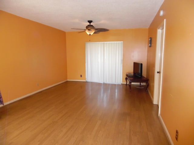 empty room with hardwood / wood-style floors and ceiling fan