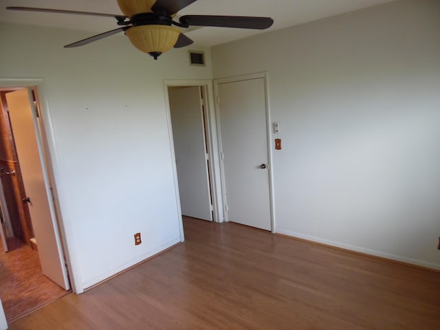 spare room with dark hardwood / wood-style floors and ceiling fan