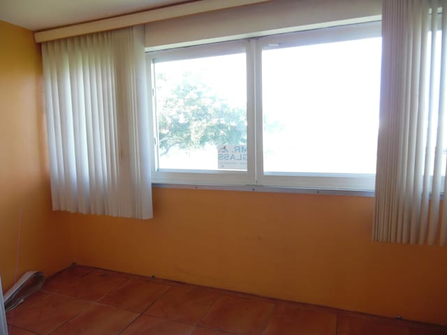 spare room with a healthy amount of sunlight and tile flooring