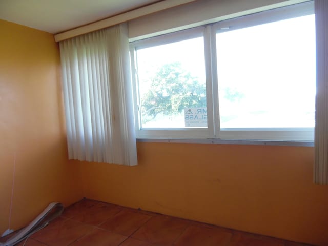 empty room featuring plenty of natural light and tile flooring