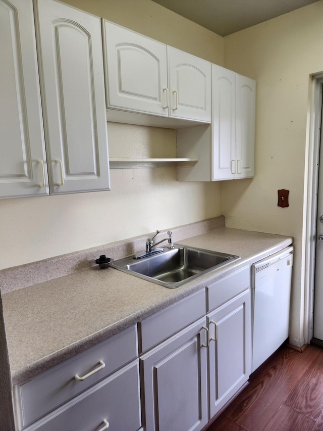 kitchen featuring white cabinets, white dishwasher, dark wood-type flooring, and sink