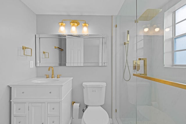 bathroom with a shower with shower door, toilet, and vanity