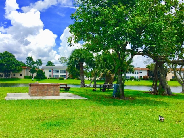 view of home's community with a water view and a lawn