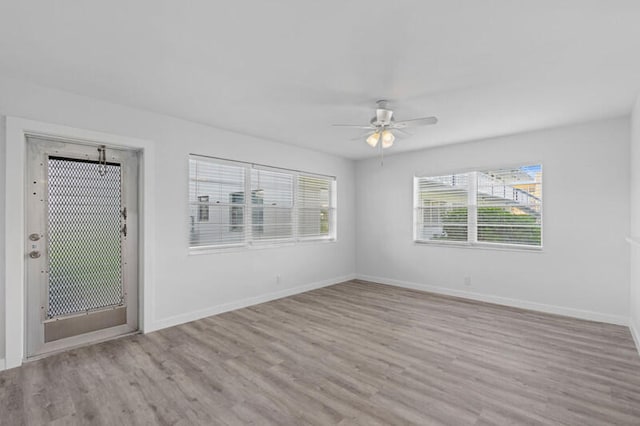 empty room with ceiling fan and light hardwood / wood-style floors