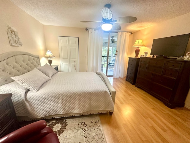 bedroom with light hardwood / wood-style floors, access to exterior, ceiling fan, a textured ceiling, and a closet